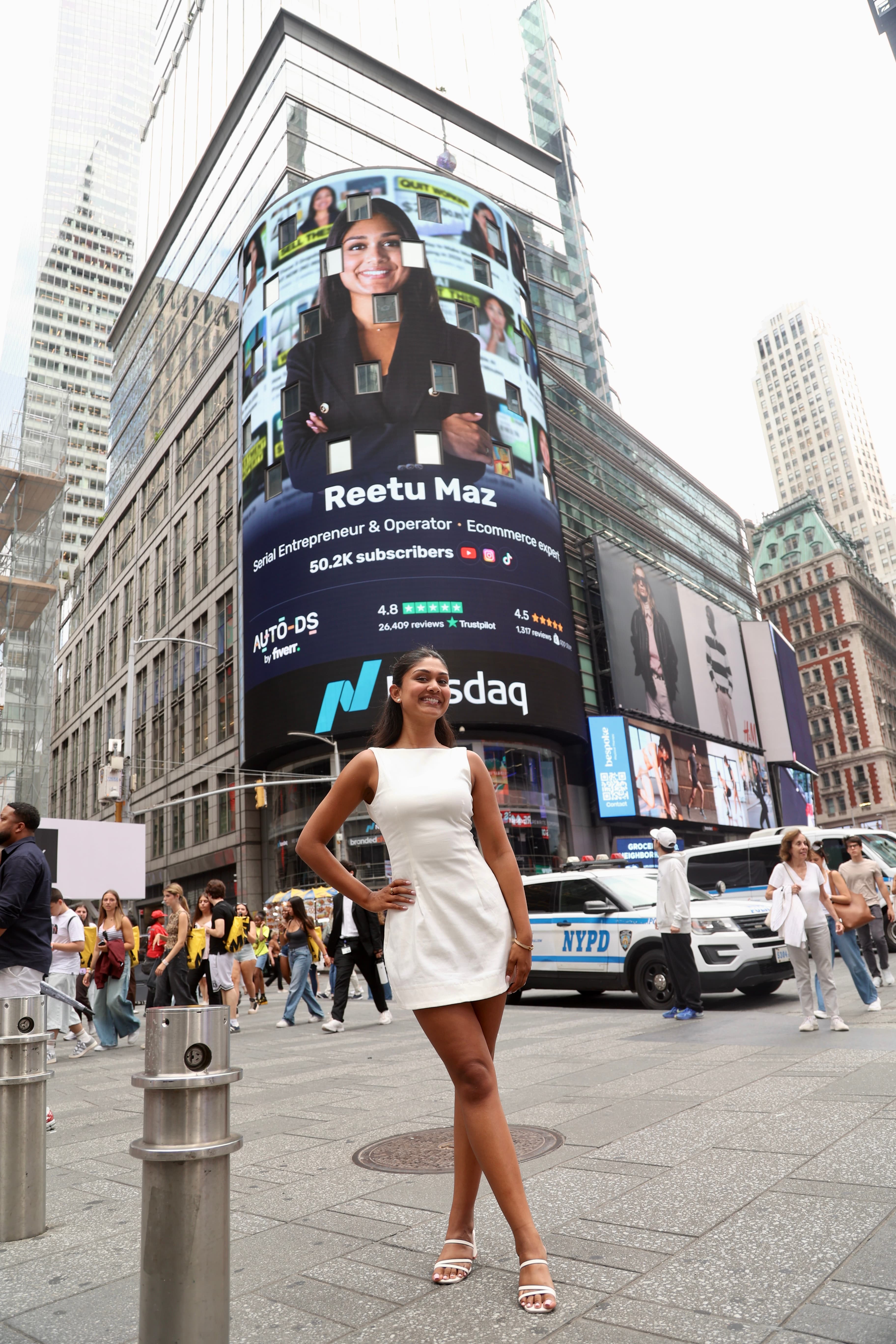 Reetu Maz standing beneath a billboard featuring her in Times Square